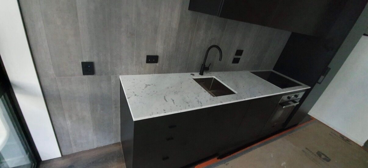 Complete kitchen renovation in Auckland with stone benchtop and brushed brass fixtures